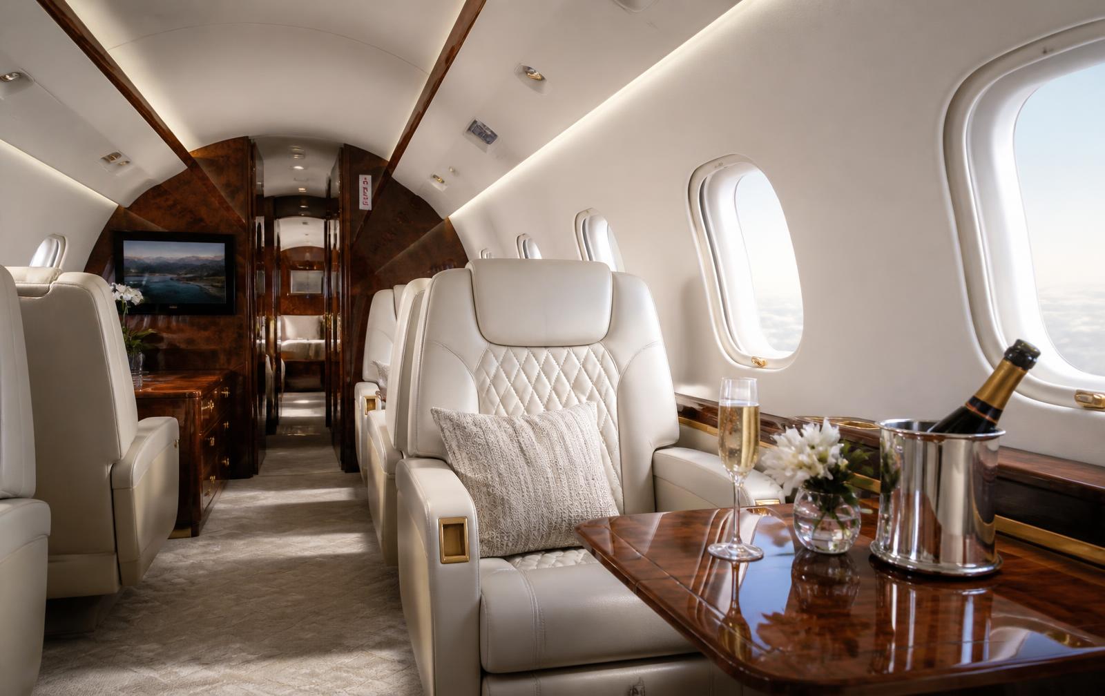Cream leather cabin interior of a private jet with polished wood detailing